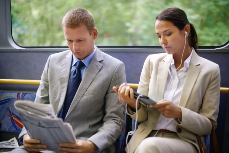 Two employees riding to work on a shuttle bus
